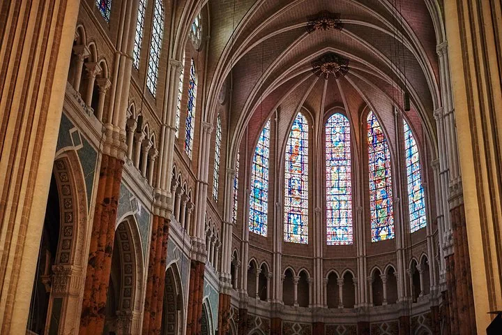 High vaulted ceilings and tall stained glass windows inside Chartres Cathedral