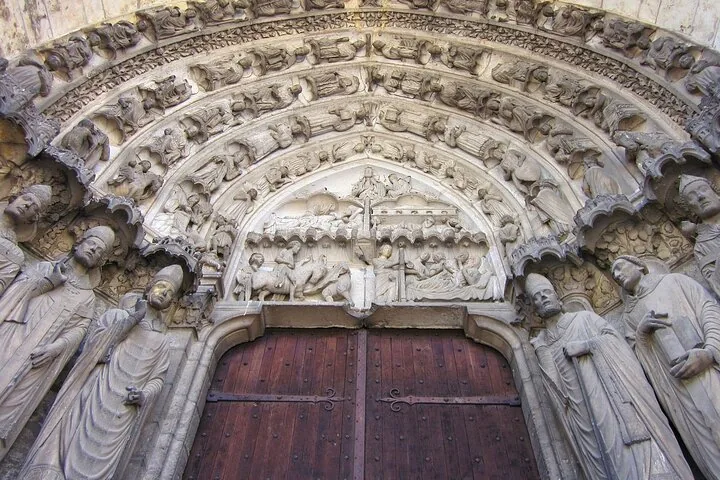 Close-up of stone statues framing a large wooden door