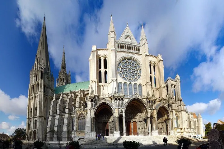 Grand entrance and facade of Chartres Cathedral under a blue sky
